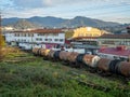 Old rusty tank wagons. Freight train on the background of the city. Industrial zone of the southern city