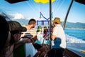 Batumi, Georgia- 26th july, 2022: boat driver with assistant and tourist in boat prepara parachute fro para sailing in summer