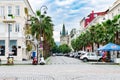 Travel to Europe, or a warm country - the central cozy city paving stone street with beautiful houses, buildings, parked cars.