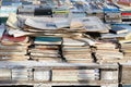 Vintage, battered russian books and papers are stacked on counter, selling old books, close up.