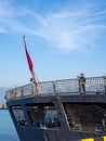 A warship is moored at the port. Patrol ship. Resort place. A sentry with a machine gun is on duty on deck. Camouflage nets Royalty Free Stock Photo