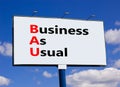 BAU business as usual symbol. Concept words BAU business as usual on white billboard against blue sky and clouds. Beautiful Royalty Free Stock Photo