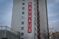 Bauhaus building with a vertical red sign displaying the company name.
