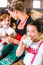 Bavaria family drinking milk in cow barn