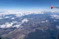 View from an airplane on the wing, the beautiful white clouds and fields with wind turbines on the ground