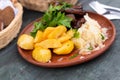 Bavarian baked pork ribs with boiled potatoes and sauerkraut closeup Royalty Free Stock Photo