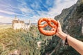 Bavarian brezel or pretzel on the background of the famous German castle Neuschwanstein. Travel and tourism concept