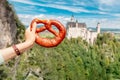 Bavarian brezel or pretzel on the background of the famous German castle Neuschwanstein. Travel and tourism concept Royalty Free Stock Photo