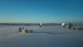Bavarian church and radio telescopes of Raisting with snow during winter and sunset from above