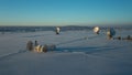 Bavarian church and radio telescopes of Raisting with snow during winter and sunset from above