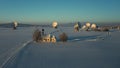 Bavarian church and radio telescopes of Raisting with snow during winter and sunset from above