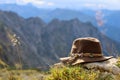 Bavarian felt hat lies in the mountains in front of a grandiose mountain panorama of the Alps, concept of wanderlust