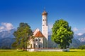 Bavarian landscape - view of the church of St. Coloman on the background of the Alpine mountains