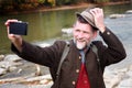 Bavarian man in his 50s standing by river and taking a selfie Royalty Free Stock Photo