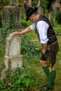 Bavarian man standing in front of grave Royalty Free Stock Photo