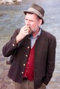 Bavarian man standing by river and eating apple Royalty Free Stock Photo