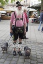 Bavarian man with two dachshunds. typical and original Bavarian senior man in garb: lederhosen, checquered shirt, traditional hat