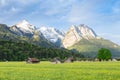 Bavarian serene landscape with snowy Alps mountains and spring flowering pasture in valley