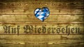 Bavarian tablecloth on wood with the German word for `Goodbye`