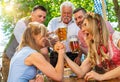 Bavarian women practicing the high art of arm wrestling with friends that cheer on in a beer garden or oktoberfest Royalty Free Stock Photo