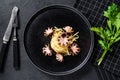 Bavette pasta with baby octopus. Black background. Top view