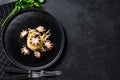 Bavette pasta with baby octopus. Black background. Top view. Space for text