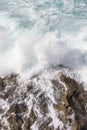 Foamy waves of the surf near the rocky shore