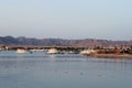 Bay and boats on the water. Boat station on the shore. Low mountains in the distance. Resort on the Red sea coast, Egypt Royalty Free Stock Photo