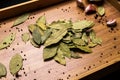 Bay leaf on a wooden background. Garlic and pepper in a pot. View from above. Seasoning flavoring for meat and food.