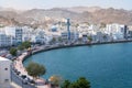 Bay of the old town of Muscat, Oman on a hot day. Blue mosque and minaret, white buildings and sandstone rock in the Royalty Free Stock Photo