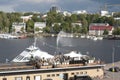 Bay with white ships. People walking along the promenade in the summer. Lappeenranta embankment.