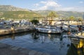 Bay with yachts in Budva city, Adriatic sea. Shoreline of touristic town with boats for rent and mountain view.