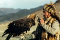Berkutchi Kazakh Eagle Hunter while hunting to the hare with a golden eagles on his arms Royalty Free Stock Photo