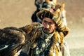 Berkutchi Kazakh Eagle Hunter while hunting to the hare with a golden eagles on his arms Royalty Free Stock Photo