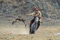 BAYAN-ULGII, MONGOLIA - OCTOBER 01, 2017: Traditional Golden Eagle Festival. The Flying Golden Eagle And Unknown Mongolian Hunter