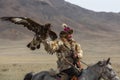 Kazakh Eagle Hunter traditional clothing, while hunting to the hare holding a golden eagle on his arm in desert mountain Royalty Free Stock Photo