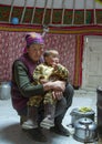 Mongolian nomad woman with her kid inside her home yurt