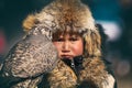 Bayan-Ulgii, Western Mongolia - October 07, 2018: Nomad Games, Golden Eagle Festival. Mongolian Boy With Offended Eyes Holding A B