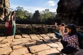 Bayon temple, head and faces made in stone. Tourist visiting and taking pictures.