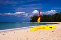 Baywatch on Phuket Nayang beach, Thailand: View on yellow and red surf board and flag in tropical with white sand