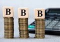 BBB - acronym on wooden cubes on the background of coins and calculator