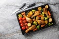 BBQ baked chicken drumsticks with seasonal vegetables and rosemary close-up on a baking sheet. Horizontal top view Royalty Free Stock Photo