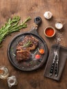 BBQ  beef steak grill with smoke, sauce, oil, salt and rosemary on black board on wooden background Royalty Free Stock Photo