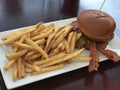 BBQ Cheeseburger with French Fries on a Dining Table Royalty Free Stock Photo