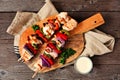 BBQ chicken kebabs with grilled vegetables on a serving board over wood Royalty Free Stock Photo