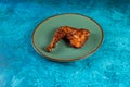 bbq chicken leg piece served in a dish isolated on background side view