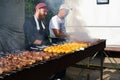 Russia, Moscow, 26-28th July 2019, BBQ festival in Moscow, Sokolniki park. Two male chefs in caps cooking meat and potato on skewe