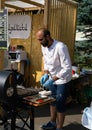 Russia, Moscow, 26-28th July 2019, BBQ festival in Moscow, Sokolniki park. Male chef in blue gloves cooking meat on skewers during