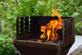 BBQ grill flame burning fire, barbecue outdoors for cooking food in garden. Big and tall grill flames on barbecue, green Royalty Free Stock Photo