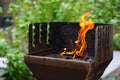 BBQ grill flame burning fire, barbecue outdoors for cooking food in garden. Big and tall grill flames on barbecue, green Royalty Free Stock Photo
